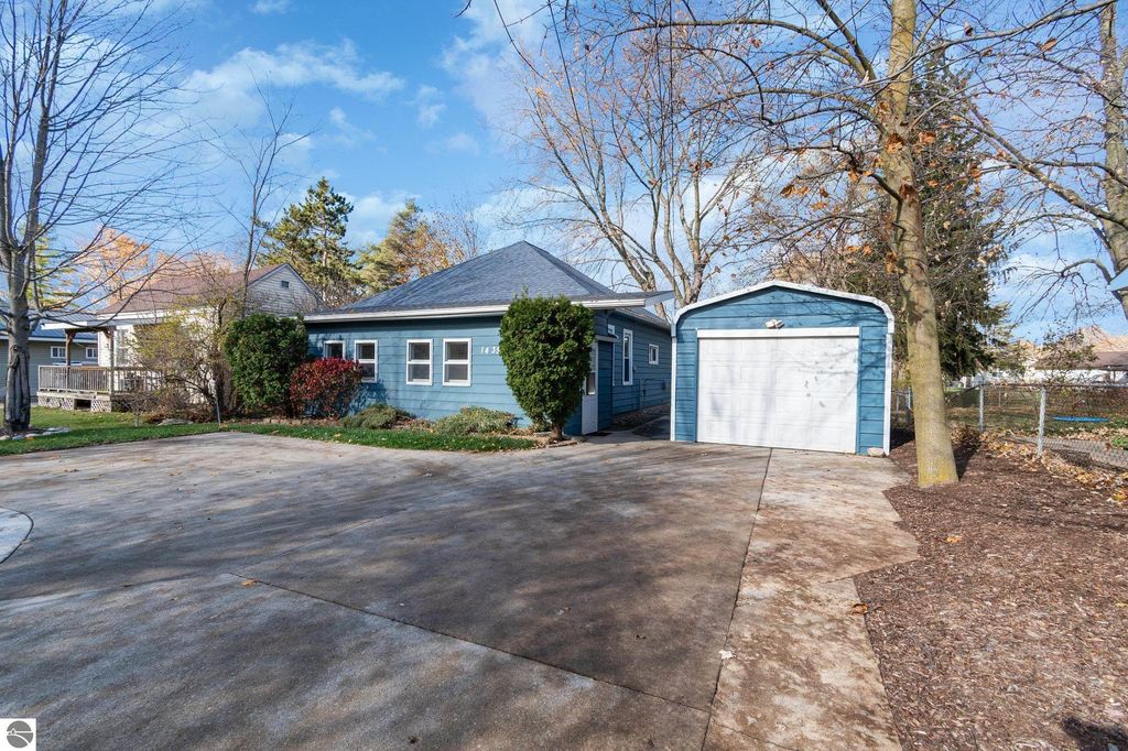 Single-family home at 1435 E Broadway Street, Mt Pleasant, MI, featuring a blue exterior, one-car garage, and landscaped yard.