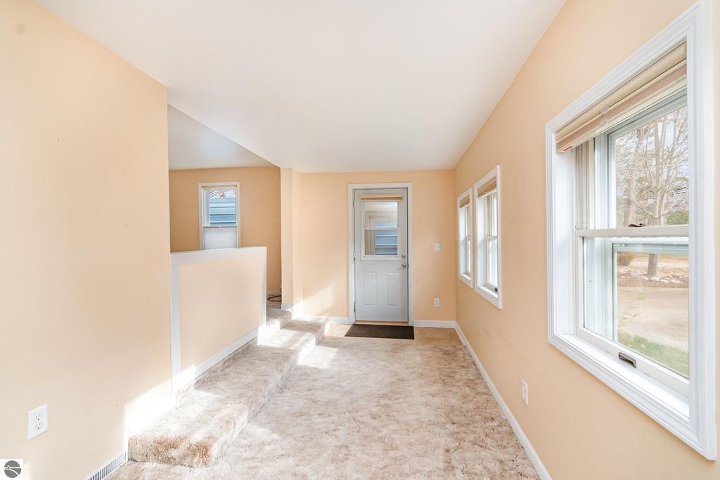 Interior view of a move-in ready 2-bedroom home in Mt Pleasant, featuring a mudroom entry, beige walls, and natural light from multiple windows.