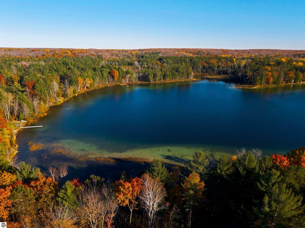 Aerial view of Pickerel Lake surrounded by autumn foliage and forest, showcasing clear blue-green water and potential building site for a dream home or getaway.