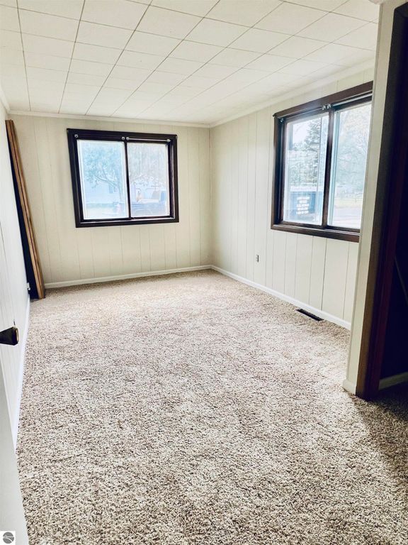 Spacious interior of a three-bedroom home at 889 N Ferris Road, featuring light-colored walls, large windows, and plush carpeting, showcasing the inviting living space for potential buyers.