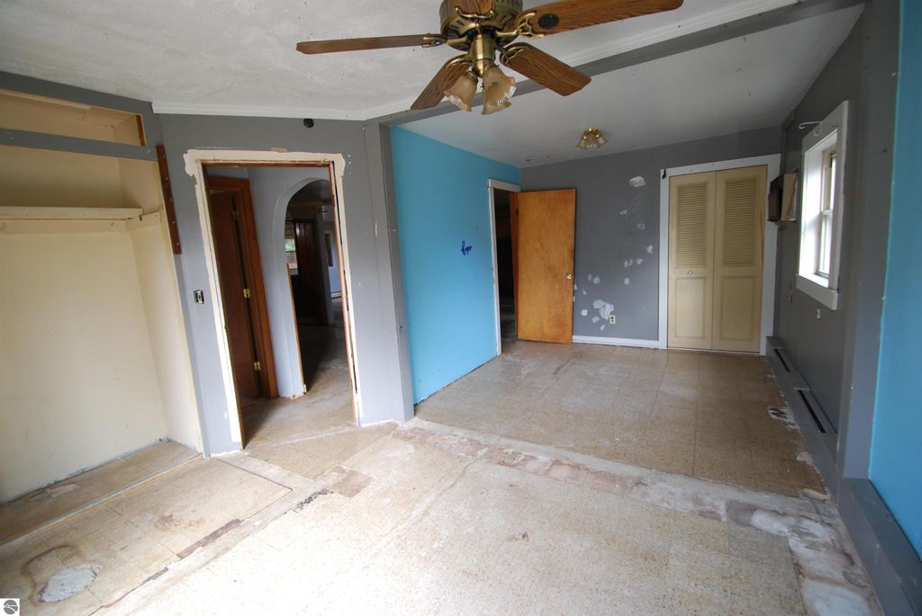 Interior view of a fixer-upper home at 1532 Rabbit Track Drive, featuring spacious rooms, a ceiling fan, and unfinished flooring, highlighting its potential for renovation.