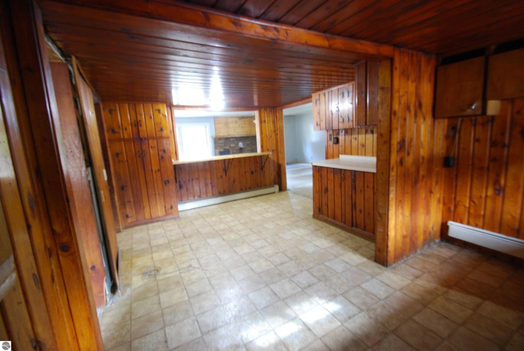 Interior view of a fixer-upper home at 1532 Rabbit Track Drive, featuring wooden paneling, spacious layout, and an open kitchen area, suitable for potential buyers interested in renovation opportunities.
