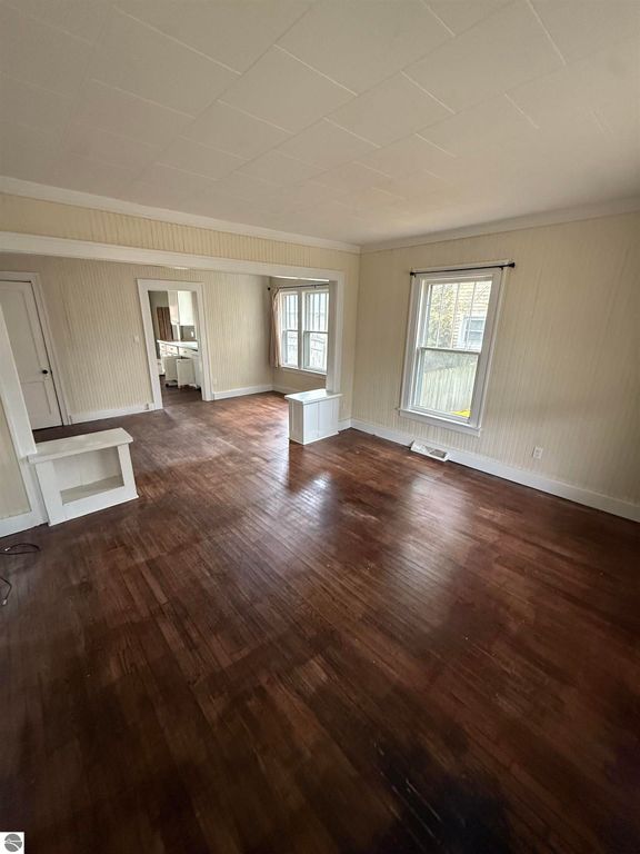 Spacious living area with hardwood floors, natural light from windows, and a welcoming layout in a home at 610 S Washington Street, Mt Pleasant, MI.
