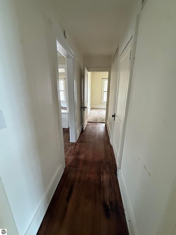 Hallway view inside 610 S Washington Street, showcasing wooden flooring, white walls, and doorways leading to adjacent rooms, emphasizing the home's inviting interior layout.