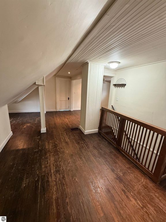 Upper-level hallway of a residential property at 610 S Washington Street, featuring hardwood floors, white walls, and a wooden railing, highlighting spacious layout and natural light.