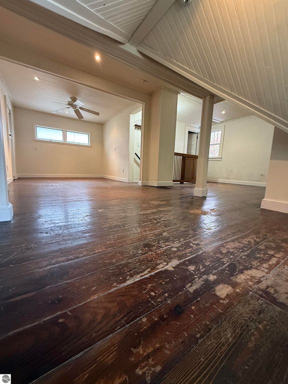 Spacious interior of 610 S Washington Street, featuring polished hardwood floors, ceiling fan, and natural light from multiple windows, highlighting the inviting living space of this Mt Pleasant home.