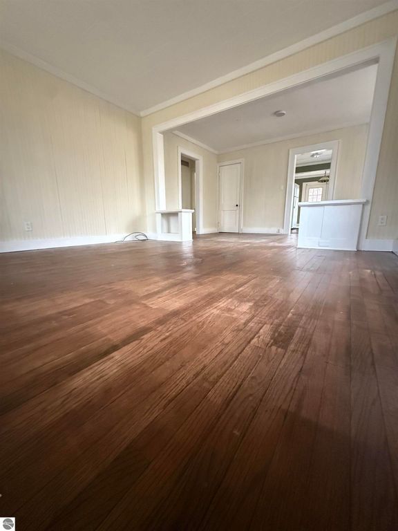 Interior view of living space at 610 S Washington Street, featuring hardwood floors, light-colored walls, and doorways leading to additional rooms, emphasizing spaciousness and natural light.