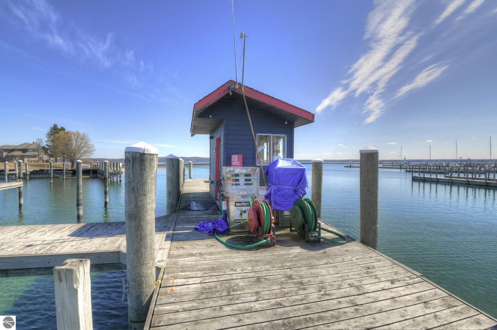 Dockside fuel station and equipment at private marina in Traverse City, Michigan, with scenic West Bay view and wooden pier.
