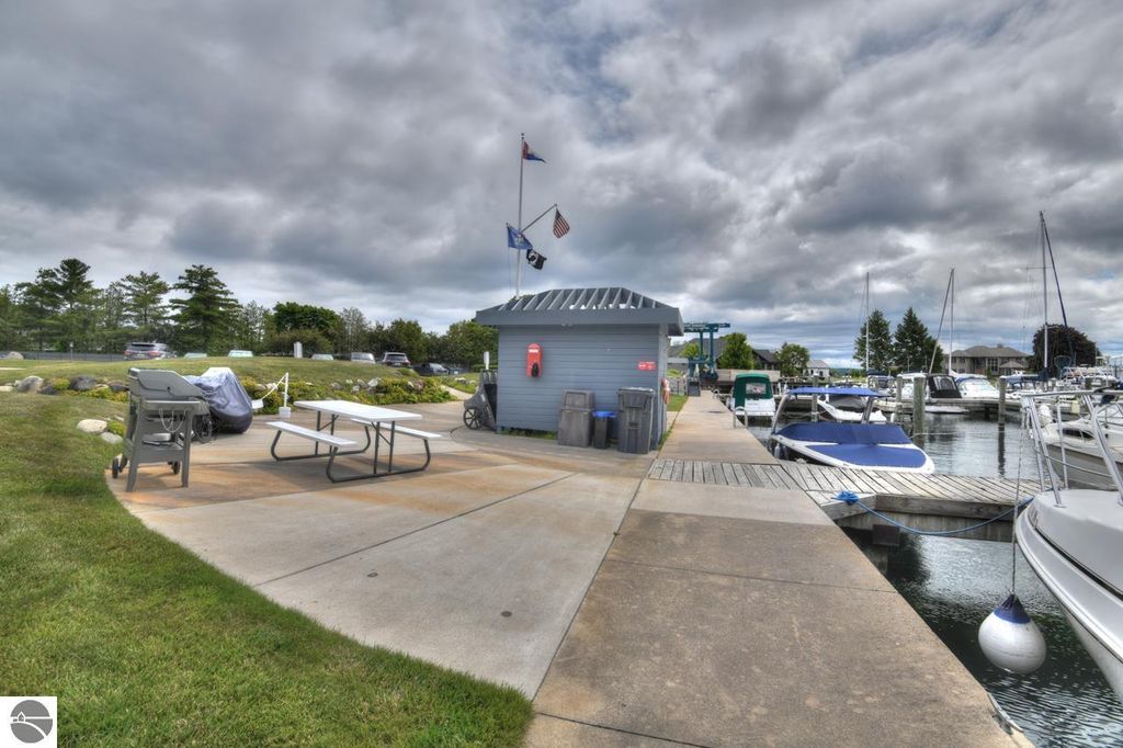 Marina area at 12755 S Marina Village Drive in Traverse City, featuring a dock, seating area, and access to boats, with amenities for boat enthusiasts.
