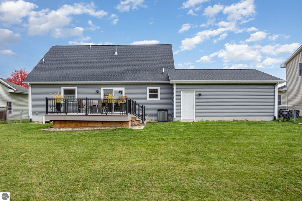 Updated exterior of 1932 Churchill Boulevard, Mt Pleasant, MI, featuring a new roof and siding, spacious composite deck, and fenced backyard in a desirable neighborhood.