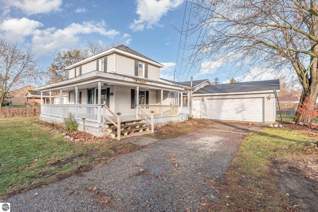 Spacious two-story home at 1708 W Lyons Street, Mt Pleasant, featuring a wrap-around porch, two-car garage, and large yard.