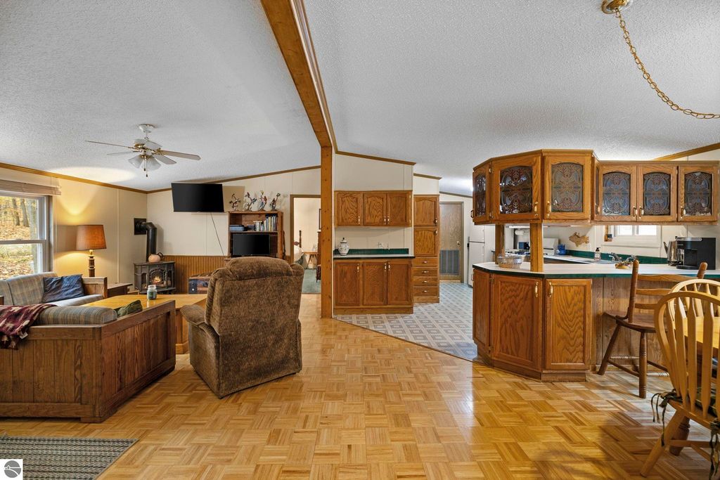 Inviting interior of a 3-bedroom, 2-bath home featuring an open layout, wooden cabinetry, and cozy living area, showcasing Up North living in Blue Lake Heights, Kalkaska, MI.