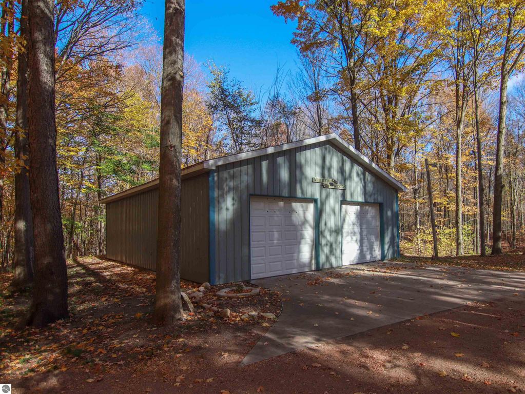 Detached 30x40 pole barn with two garage doors, surrounded by autumn foliage and trees, located on 8.75 acres at 20280 Cadillac Highway, Copemish, MI.