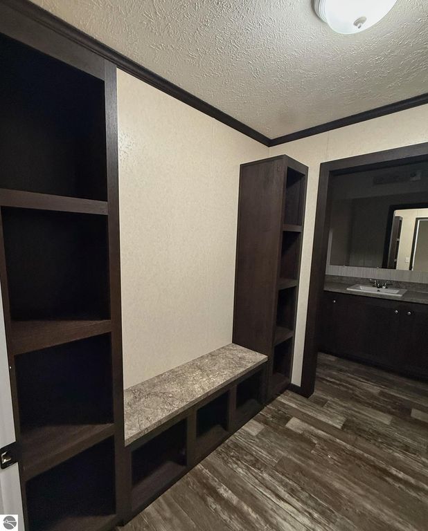 Interior view of a cozy entryway featuring built-in shelving, a stone bench, and a doorway leading to a bathroom, showcasing the charm of the 3-bedroom house at 1032 Pebble Creek, Mt Pleasant, MI.