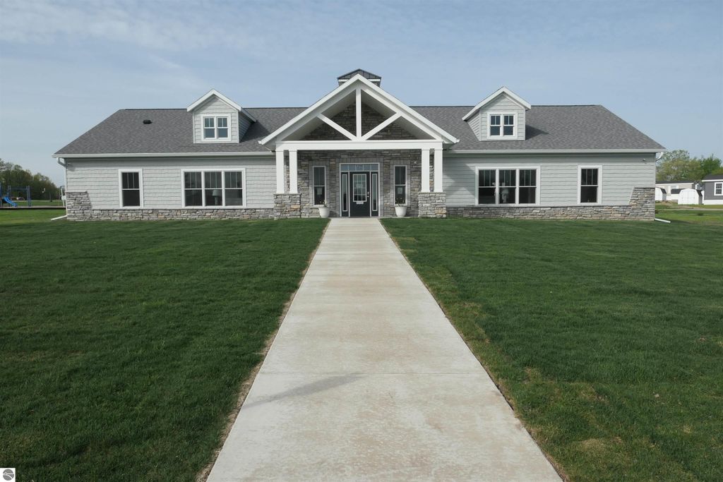 New clubhouse at Summerhill Village, featuring modern architecture, stone accents, and a landscaped lawn, ideal for community gatherings and recreational activities.