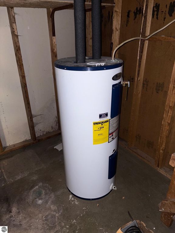 Water heater in basement of ranch-style home at 8721 Glover Lake Road, Bear Lake, MI, featuring Energuide label and venting pipes.