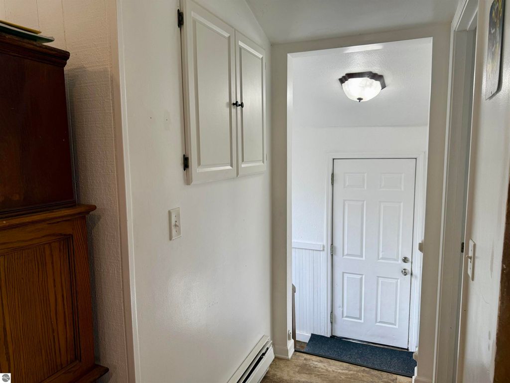 Interior hallway view of 711 Francisco Avenue, showing the entrance door, white walls, and wooden furniture, highlighting the home's layout and inviting atmosphere for potential buyers.