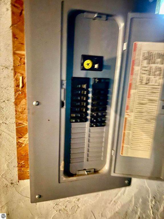 Electrical panel with circuit breakers and safety switch, located in the basement of a residential property for sale at 711 Francisco Avenue, Alma, MI, highlighting essential utilities for potential buyers and investors.
