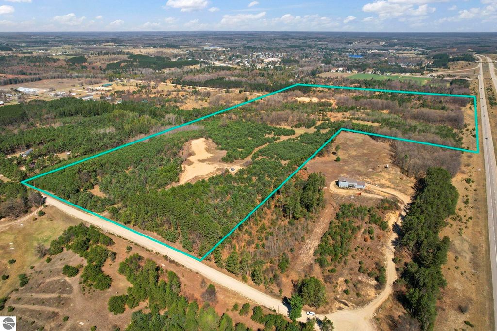 Aerial view of 7.62-acre wooded parcel for sale on E 18 1/2 Road, Manton, MI, featuring natural landscape, privacy, and proximity to downtown and outdoor activities.