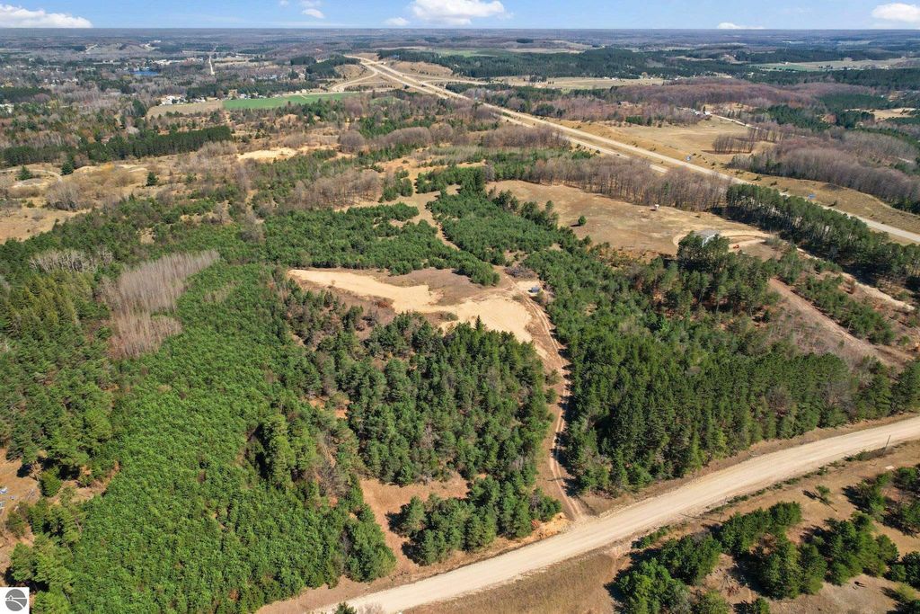 Aerial view of 7.62-acre wooded parcel in Manton, MI, featuring lush greenery and open space, ideal for outdoor activities and privacy, close to downtown and Cadillac.