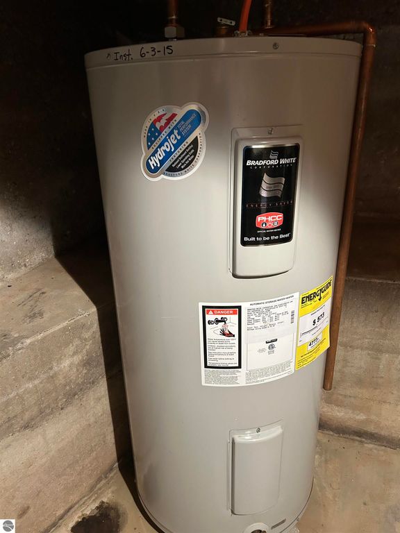 Water heater by Bradford White with energy efficiency label, installed on June 3, 2015, located in a basement setting.