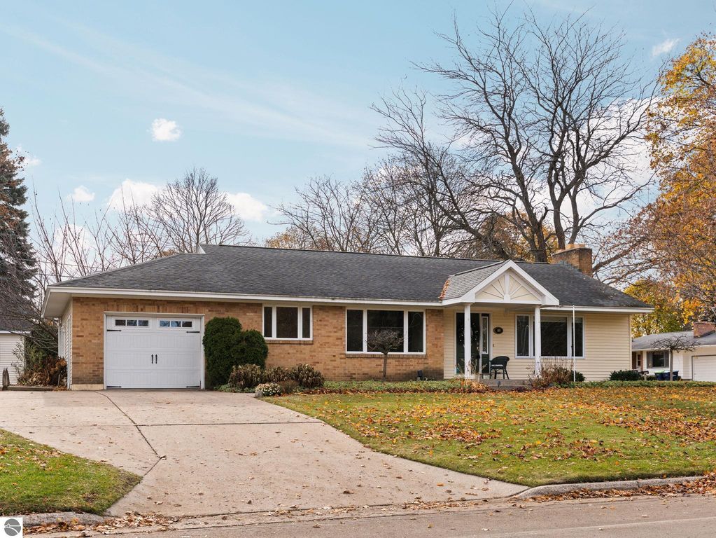 Ranch-style home at 109 Boughey Street, Traverse City, MI, featuring autumn foliage, a spacious front yard, and a welcoming entrance with a cozy porch.