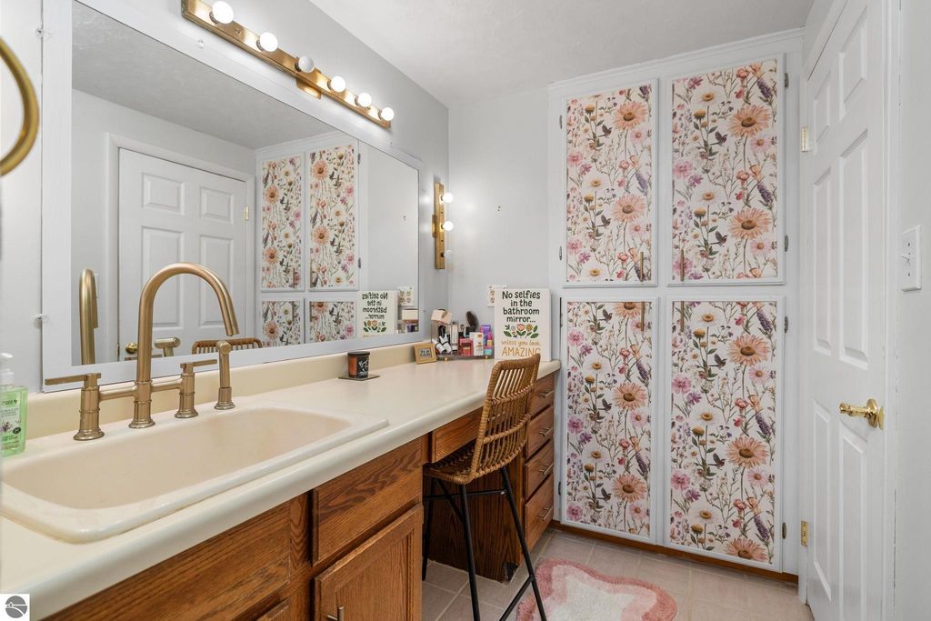 Cozy finished basement room with beige walls, carpeted flooring, and a white door, ideal for a potential fifth bedroom or home office in Traverse City ranch at 109 Boughey Street.
