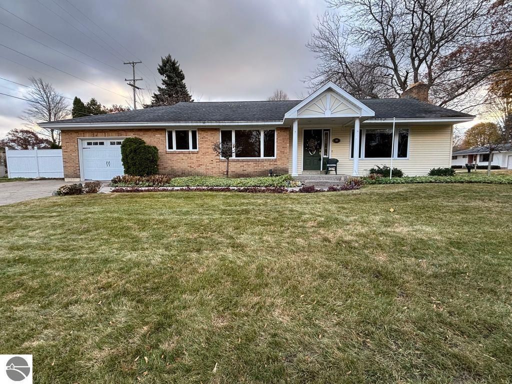 Ranch-style home at 109 Boughey Street, Traverse City, featuring a brick exterior, landscaped front yard, and attached garage, ideal for family living.