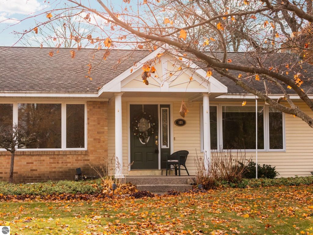 Ranch-style home at 109 Boughey Street, Traverse City, featuring a brick facade, attached garage, and landscaped front yard with autumn leaves.