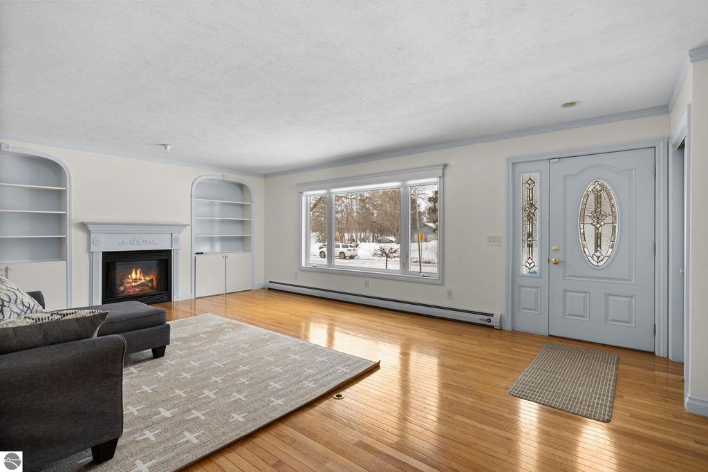 Front view of 109 Boughey Street, Traverse City, MI, showcasing a ranch-style home with a welcoming entrance, decorative wreath, and autumn leaves scattered on the lawn.