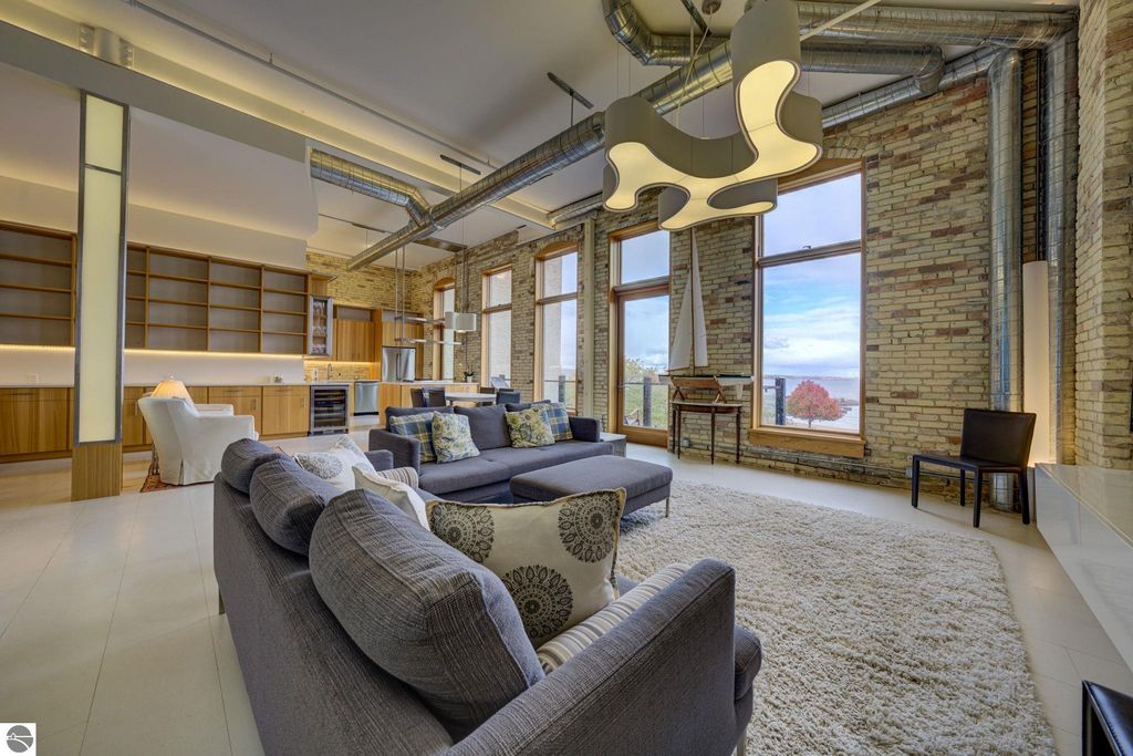 Modern downtown condo interior with open layout, large windows showcasing bay views, stylish furnishings, and contemporary lighting, emphasizing luxury living at 237 E Front Street, Traverse City, MI.