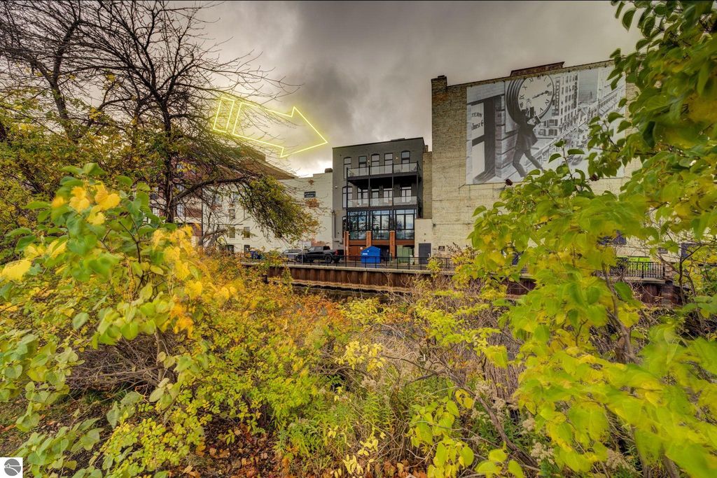 Modern downtown condo at 237 E Front Street, Traverse City, featuring a mural, surrounded by autumn foliage and views of the bay.