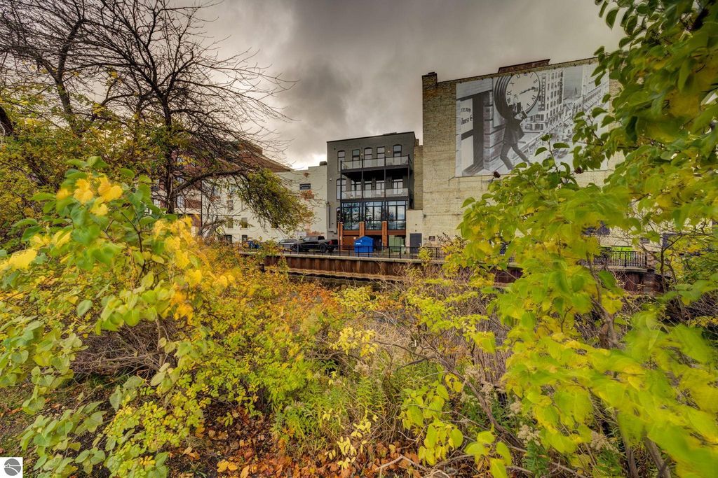 Modern downtown condo at 237 E Front Street, Traverse City, surrounded by autumn foliage and a mural, showcasing urban living with scenic views.