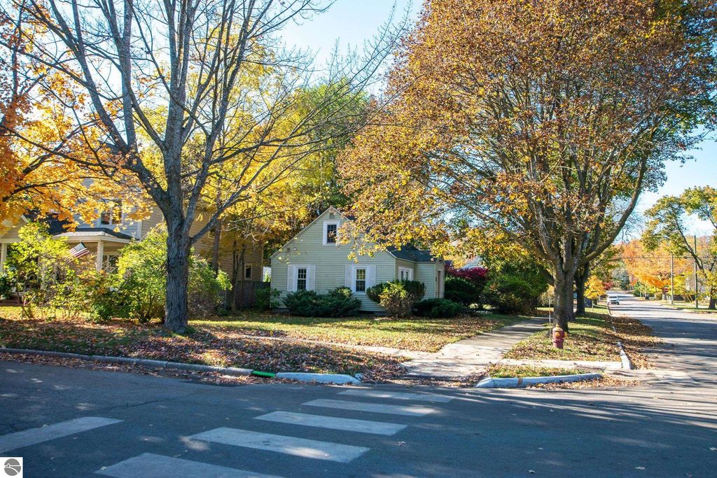 Residential neighborhood in Traverse City, showcasing a 2-bedroom ranch home surrounded by autumn foliage, emphasizing the property’s potential on a spacious lot.