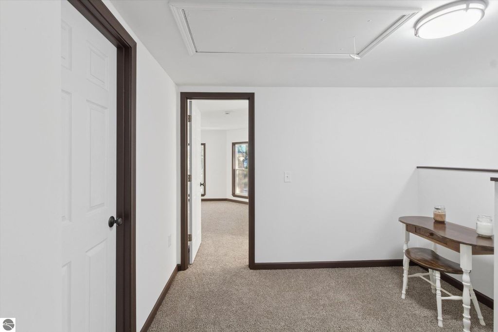 Interior hallway of a renovated home at 117 E Wright Avenue, featuring white walls, brown trim, and a small table with decorative items, illustrating the spacious and updated living space.