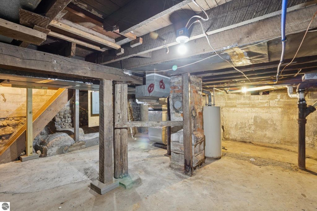 Basement interior of renovated home at 117 E Wright Avenue, featuring exposed wooden beams, new plumbing, and updated heating system, showcasing the property's modern renovations and structural integrity.