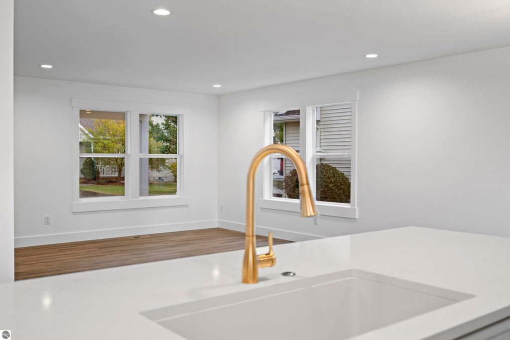 Modern kitchen with quartz countertops, gold faucet, and bright windows showcasing natural light in new home at 2737 Ruby Street, Traverse City, MI.