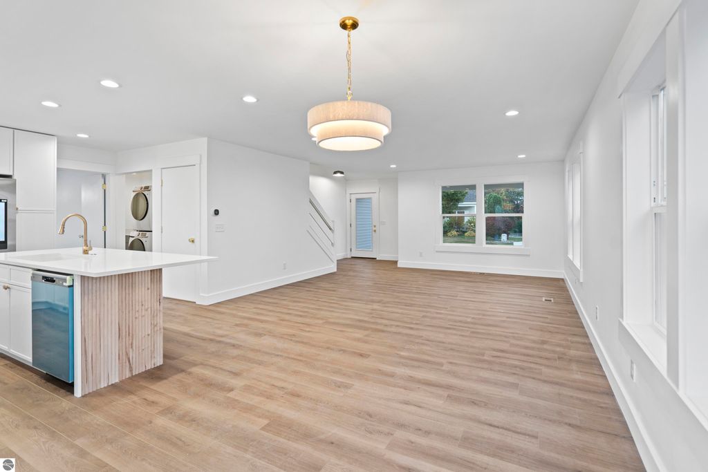 Bright and spacious interior of a modern home featuring a custom kitchen island with quartz countertops, energy-efficient appliances, and an open layout, showcasing quality craftsmanship and design elements in Traverse City, MI.
