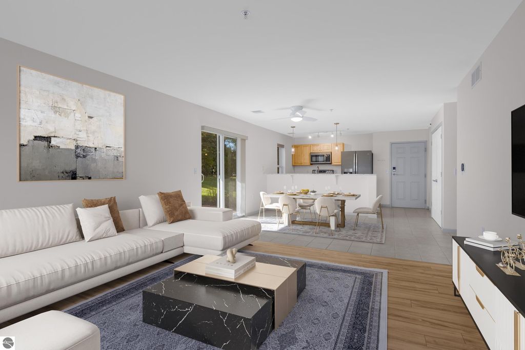 Modern living room in condo at 1122 Lake Ridge Drive, featuring a white sectional sofa, abstract wall art, dining area with modern chairs, and open kitchen with stainless steel appliances.