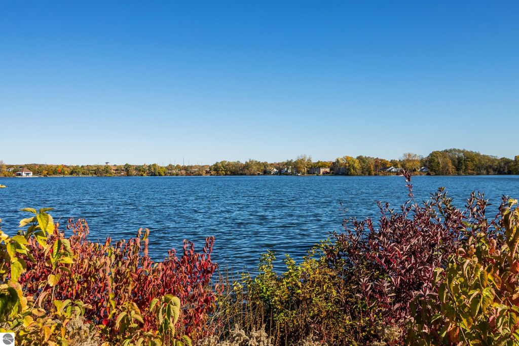 Lakeside view of Boardman Lake with colorful autumn foliage in the foreground, highlighting the serene natural setting near the condo at 1122 Lake Ridge Drive, Traverse City, MI.
