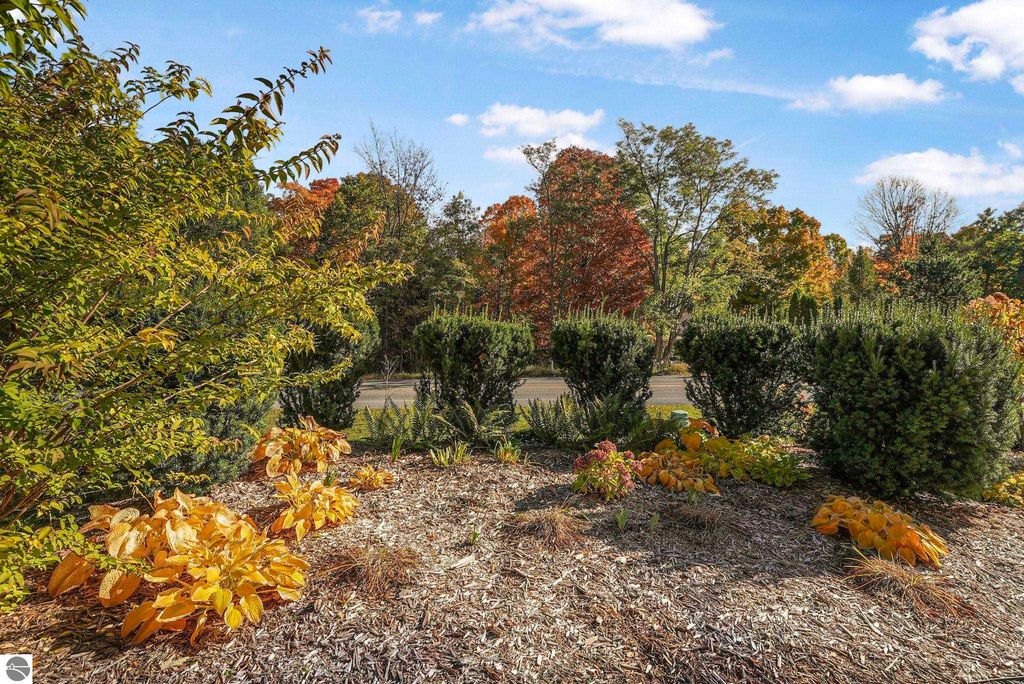 Colorful autumn foliage and landscaped garden beds at the townhouse property in Traverse City, Michigan, showcasing vibrant plants and shrubs.
