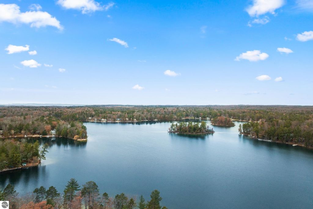 Aerial view of Spider Lake showcasing serene water, lush greenery, and private sandy shorelines, highlighting the tranquil Up North lifestyle near 4411 Lakeview Trail, Traverse City, MI.