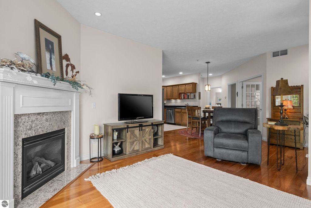 Cozy living room featuring a gas fireplace, modern television, and stylish furnishings in a 2-bedroom condo at 1420 Forest Park Drive, Traverse City, MI.