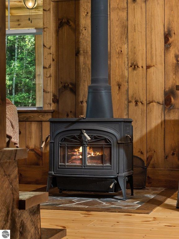 Cozy woodstove in a custom-built home with warm wooden walls, complementing the northern Michigan countryside ambiance.