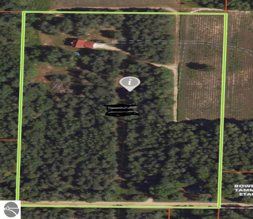 Aerial view of a 10-acre wooded property in Lake City, Michigan, featuring a red-roofed home, surrounded by lush greenery and open fields, highlighting the serene countryside setting ideal for outdoor activities.