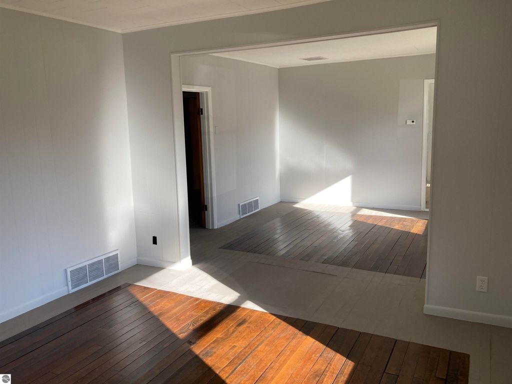 Interior view of a cozy living space in a home at 206 George Smith Jr. Street, featuring hardwood floors, neutral walls, and natural light illuminating the room.