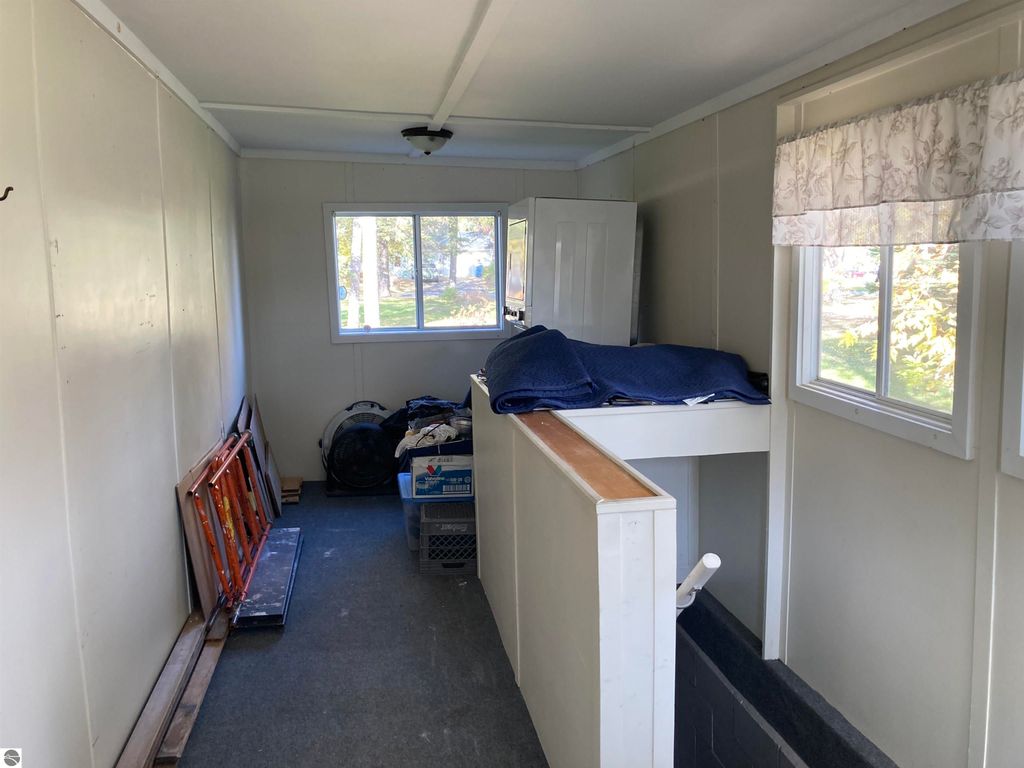 Interior view of a cozy home in Rose City, featuring a bright room with windows, a white cabinet, and storage areas, highlighting the property's potential for a comfortable living space.