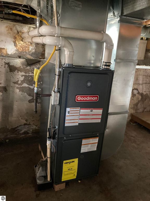 Goodman furnace in basement, highlighting efficient heating system for 206 George Smith Jr. Street, Rose City, MI real estate listing.