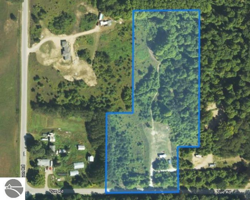 Aerial view of 8-acre wooded property at 6884 Zue Road, Buckley, MI, highlighting natural landscape, nearby road access, and outlined boundaries for potential home building and recreational use.