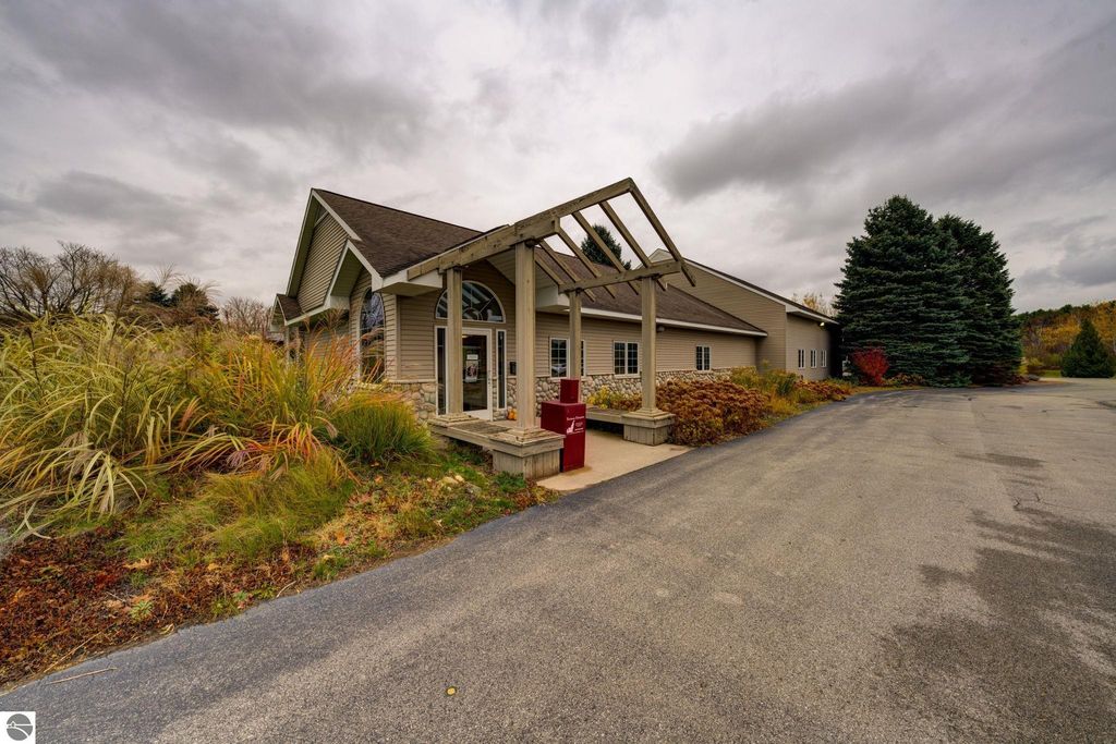 Commercial building exterior at 7200 E Duck Lake Road, Lake Leelanau, MI, featuring a modern design, landscaped surroundings, and a driveway leading to the entrance.